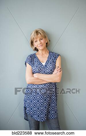 Stock Photo - Confident older Caucasian woman standing at wall. Fotosearch