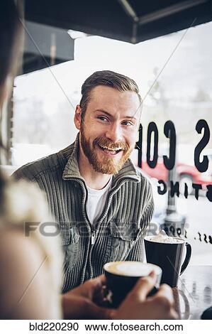 Stock Image - Couple drinking coffee in cafe. Fotosearch