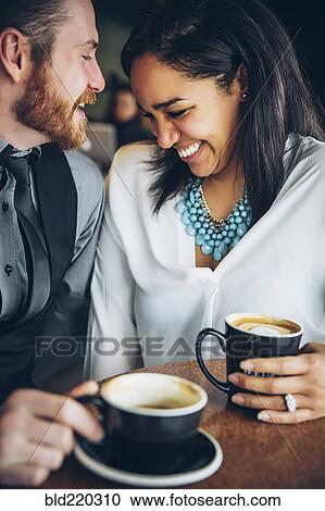 Stock Image - Couple drinking coffee in cafe. Fotosearch