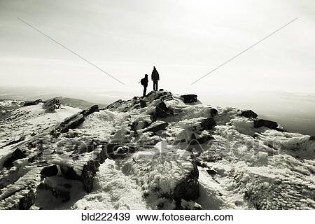 Stock Photo - Couple hiking on mountain in winter. Fotosearch
