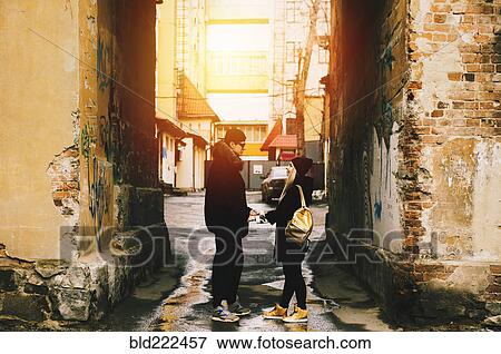 Stock Photo - Couple holding hands in urban alley. Fotosearch