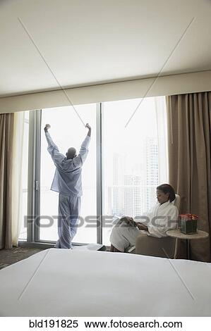 Stock Photography - Couple in pajamas and bathrobe by window. Fotosearch
