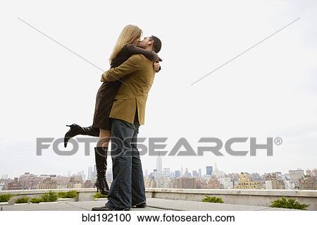 Couple kissing and hugging on rooftop View Large Photo Image Stock Image - Couple kissing and hugging on rooftop. Fotosearch