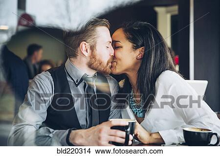 Couple kissing in cafe View Large Photo Image Picture - Couple kissing in cafe. Fotosearch