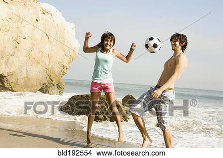 Couple playing with soccer ball on beach View Large Photo Image Picture - Couple playing with soccer ball on beach. Fotosearch