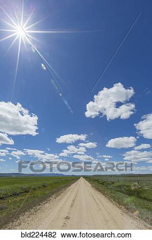 Stock Image - Dirt road toward mountains. Fotosearch