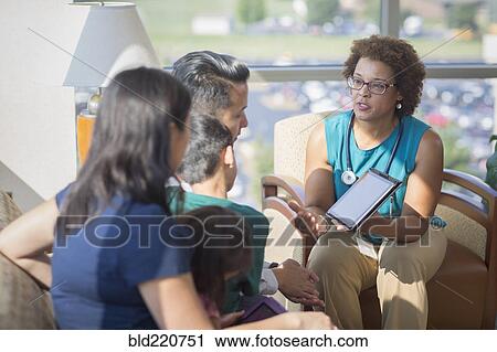 Stock Image - Doctor and patients using digital tablet. Fotosearch