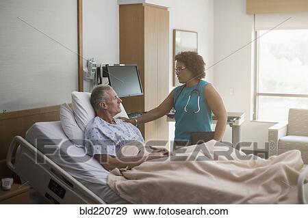 Stock Photo - Doctor talking to patient in hospital room. Fotosearch