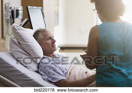 Stock Photo - Doctor talking to patient in hotel room. Fotosearch