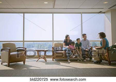 Stock Photography - Doctor talking to patients in waiting room. Fotosearch