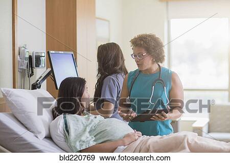 Stock Photo - Doctor talking to pregnant patient in hospital room. Fotosearch