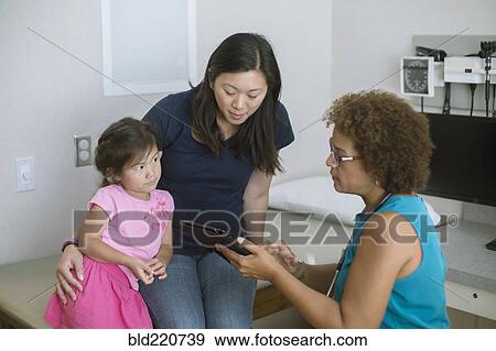 Doctor using digital tablet with patients View Large Photo Image Stock Photo - Doctor using digital tablet with patients. Fotosearch