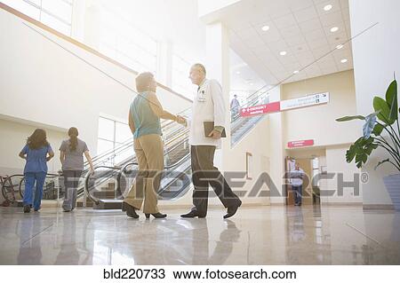 Stock Image - Doctors shaking hands in hospital. Fotosearch