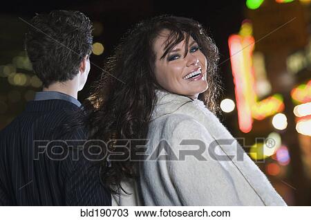Stock Image - Elegant couple walking at night. Fotosearch