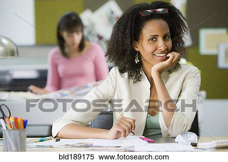 Stock Photography - Ethiopian businesswoman sitting at desk. Fotosearch