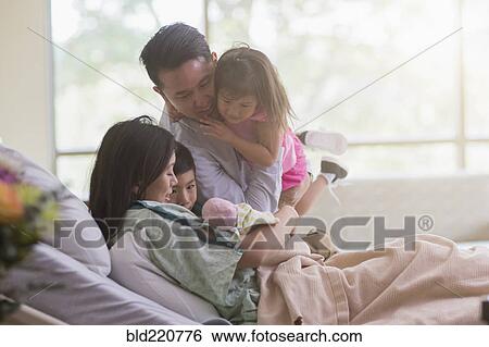 Family admiring newborn baby in hospital room View Large Photo Image Stock Photograph - Family admiring newborn baby in hospital room. Fotosearch