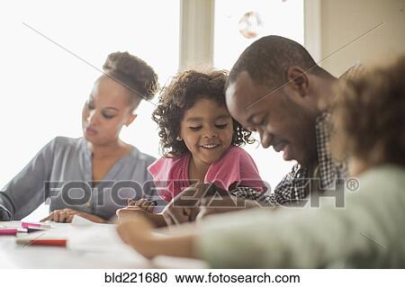 Stock Image - Family drawing together in kitchen. Fotosearch