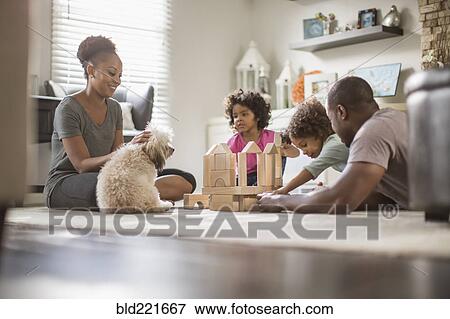 Stock Photo - Family playing with building blocks in living room. Fotosearch