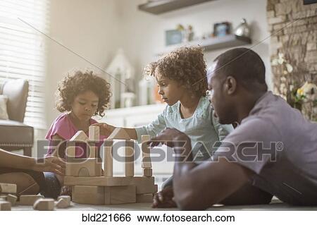 Stock Photograph - Family playing with building blocks in living room. Fotosearch