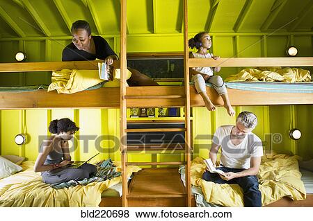 Stock Photo - Family relaxing in bunk beds at camp. Fotosearch