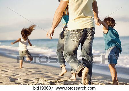 Stock Photo - Family running on beach. Fotosearch
