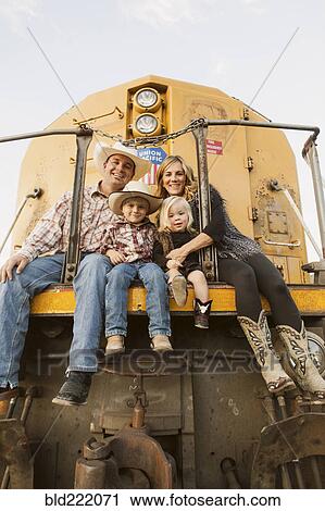 Stock Image - Family sitting on vintage train. Fotosearch