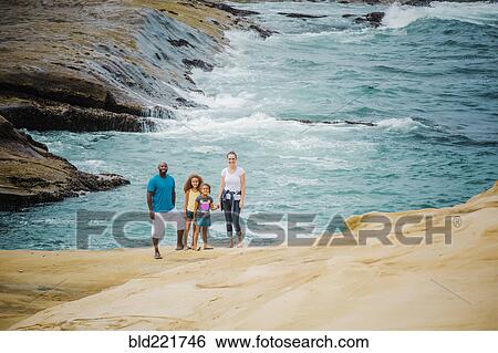 Stock Photograph - Family smiling on beach. Fotosearch
