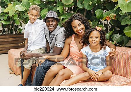 Family smiling on sofa in garden View Large Photo Image Picture - Family smiling on sofa in garden. Fotosearch