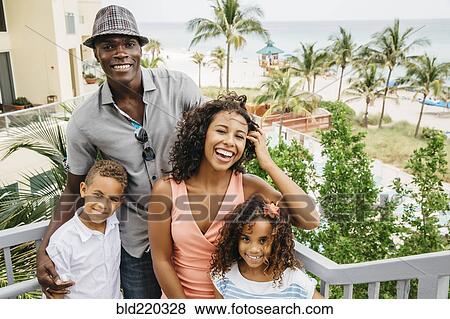Stock Photo - Family smiling on steps overlooking beach. Fotosearch