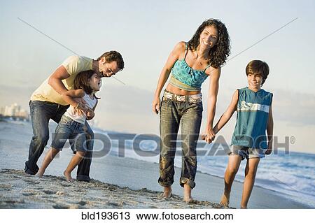 Stock Image - Family walking on beach. Fotosearch