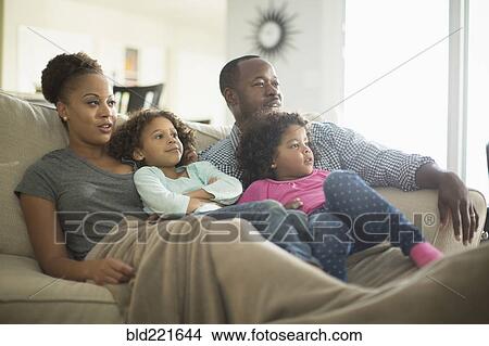 Picture - Family watching television on sofa. Fotosearch