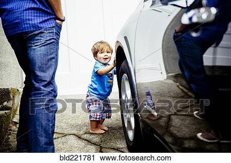 Stock Image - Father and baby son washing car. Fotosearch