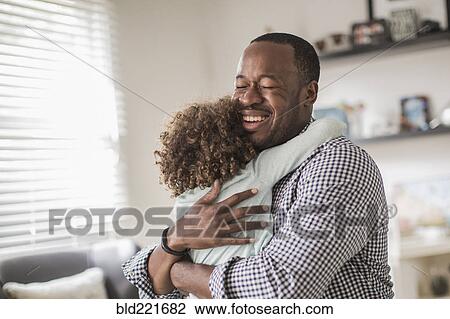 Father and daughter hugging in living room View Large Photo Image Stock Image - Father and daughter hugging in living room. Fotosearch