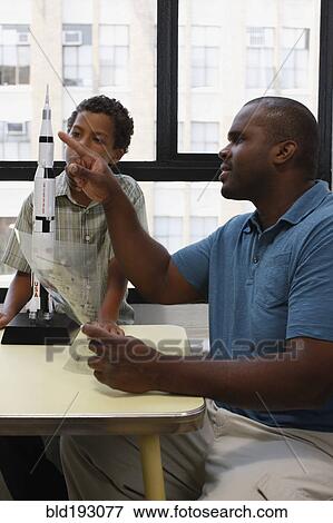 Father and son building model rocket View Large Photo Image Stock Photo - Father and son building model rocket. Fotosearch