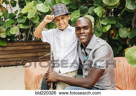 Stock Photograph - Father and son hugging in backyard. Fotosearch