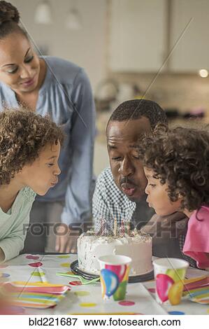 Father blowing birthday candles at party View Large Photo Image Stock Photo - Father blowing birthday candles at party. Fotosearch