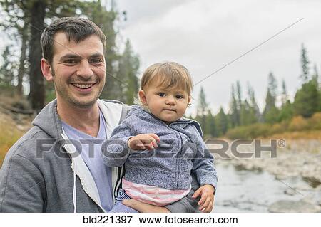 Father carrying daughter at river View Large Photo Image Stock Photo - Father carrying daughter at river. Fotosearch