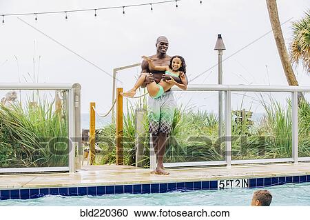 Father carrying daughter into swimming pool View Large Photo Image Stock Image - Father carrying daughter into swimming pool. Fotosearch