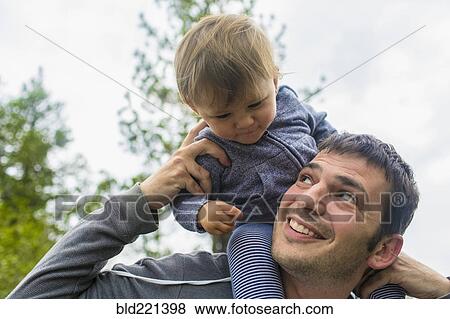 Father carrying daughter on shoulders outdoors View Large Photo Image Stock Photo - Father carrying daughter on shoulders outdoors. Fotosearch