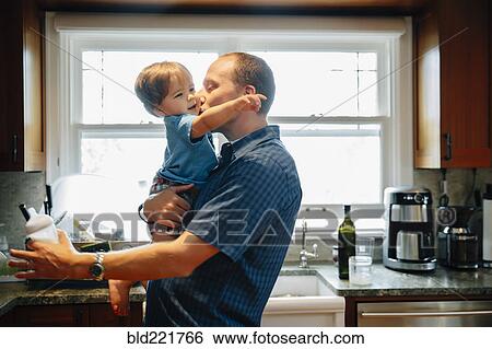 Father kissing baby son in kitchen View Large Photo Image Stock Photograph - Father kissing baby son in kitchen. Fotosearch