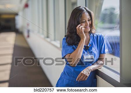 Filipino nurse talking on cell phone View Large Photo Image Stock Photo - Filipino nurse talking on cell phone. Fotosearch