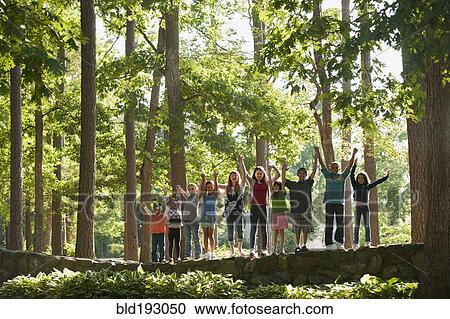 Friends cheering and standing on stone wall View Large Photo Image Stock Image - Friends cheering and standing on stone wall. Fotosearch