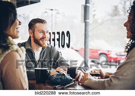 Friends drinking coffee in cafe View Large Photo Image Stock Photo - Friends drinking coffee in cafe. Fotosearch