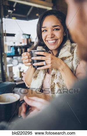Stock Photography - Friends drinking coffee in cafe. Fotosearch
