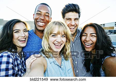 Stock Photo - Friends posing for selfie outdoors. Fotosearch