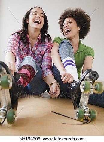 Stock Photograph - Friends putting on roller skates. Fotosearch