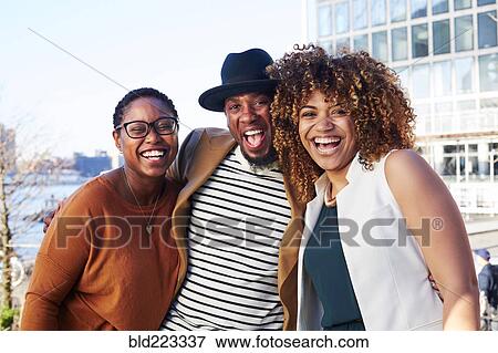Stock Photo - Friends smiling at waterfront. Fotosearch