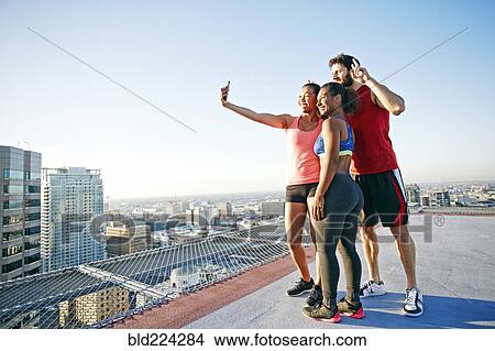 Friends taking selfie on urban rooftop View Large Photo Image Picture - Friends taking selfie on urban rooftop. Fotosearch