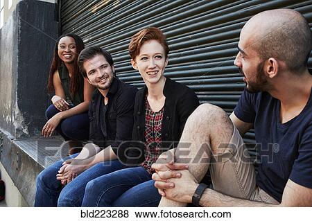 Friends talking on loading dock View Large Photo Image Stock Photo - Friends talking on loading dock. Fotosearch