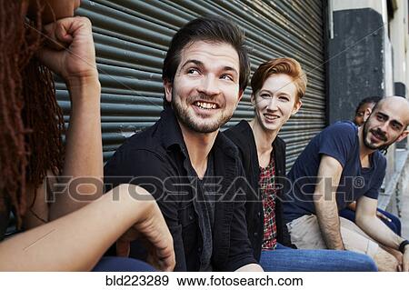 Stock Photo - Friends talking on loading dock. Fotosearch